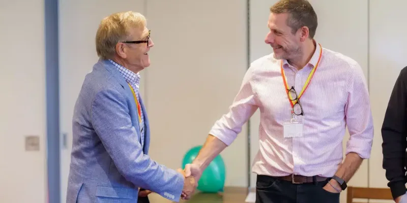 Two professionals shaking hands during a business networking meeting